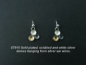 Dangly silver earrings with 3 small domes hanging off, gold, black and white.